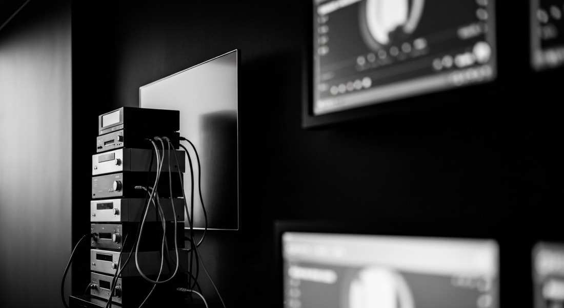 A modern wall-mounted display screen beside legacy media-player hardware